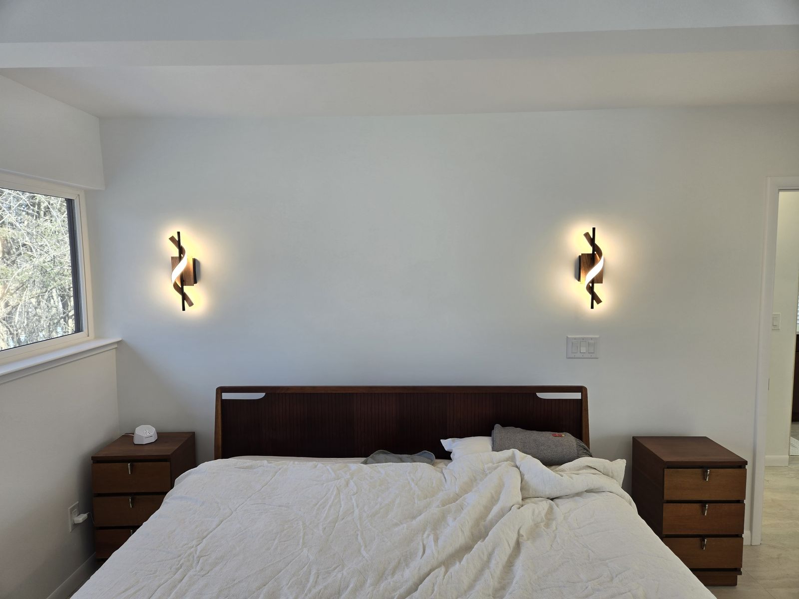 Modern wall sconces above a bed