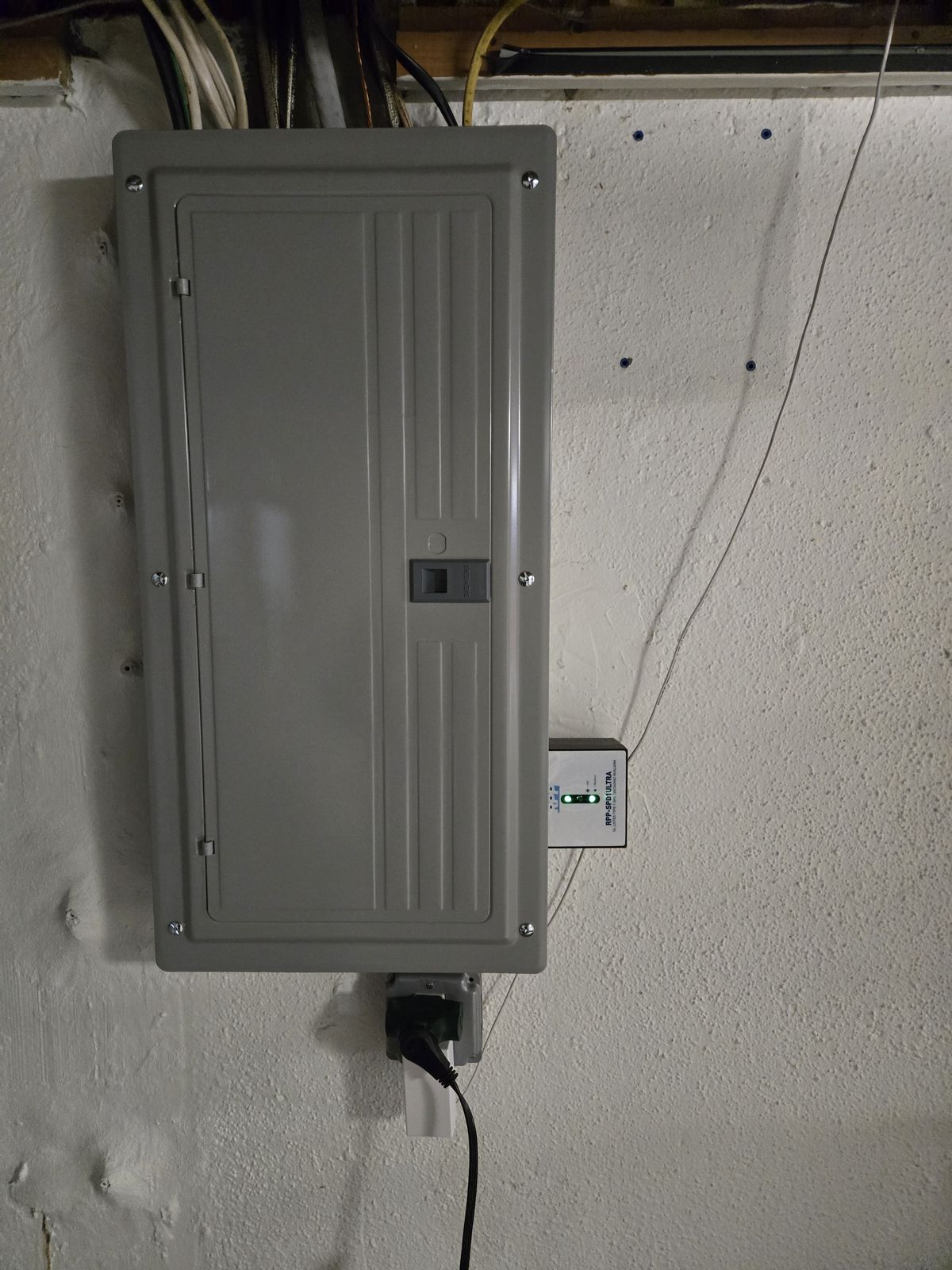Breaker panel with a surge protector mounted beside it